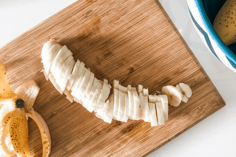 sliced banana on a wooden cutting board