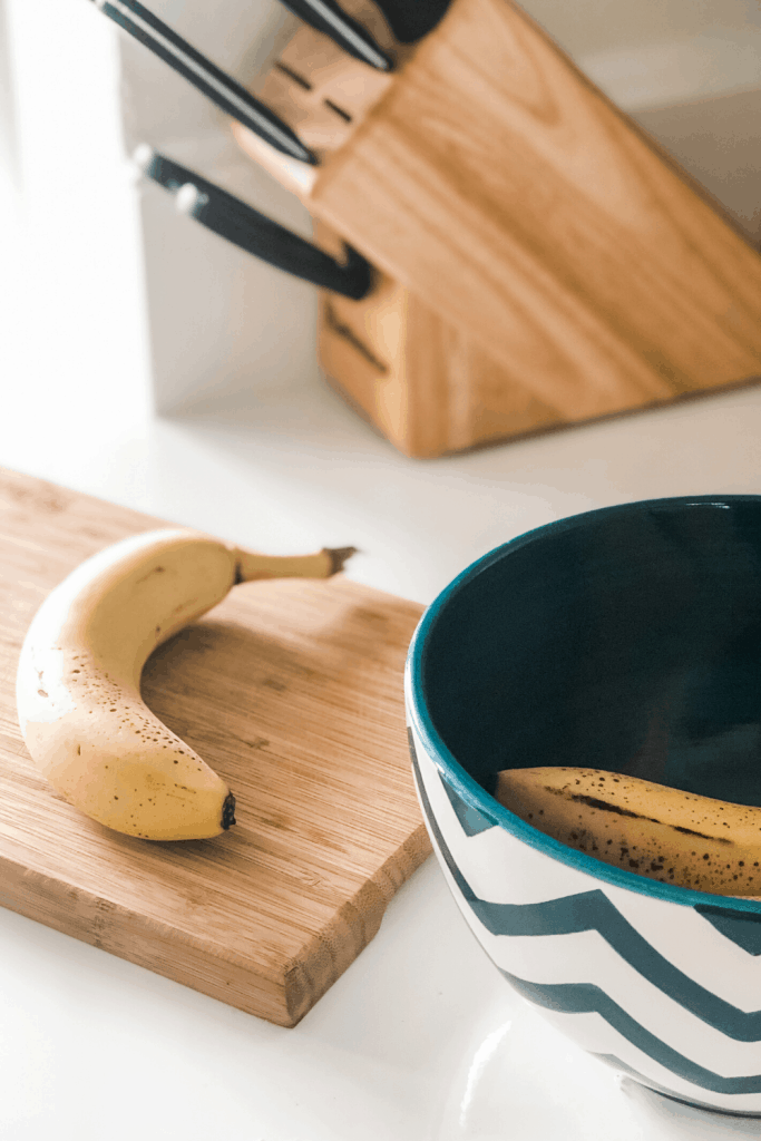 banana on cutting board with fruit bowl