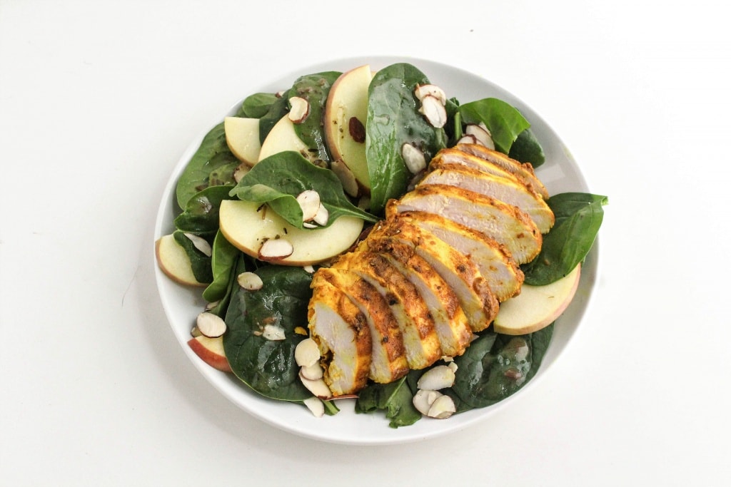 marinated chicken and spinach salad in a white bowl