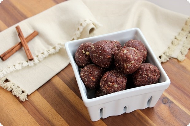 copycat cherry pie larabar cherry pie bites in a white square container with cinnamon sticks beside them