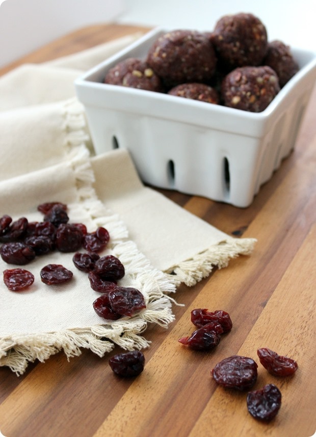 tart cherry snack balls no bake cherry bites in a white bowl with tart cherries scattered around