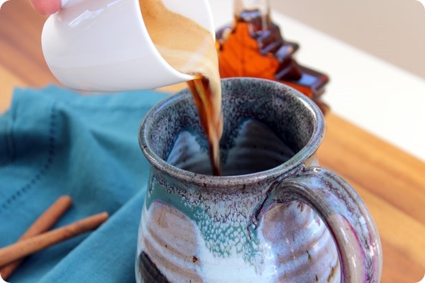 pouring espresso into a large ceramic mug