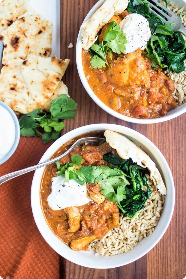 slow cooker chicken tikka masala in white bowls with naan bread