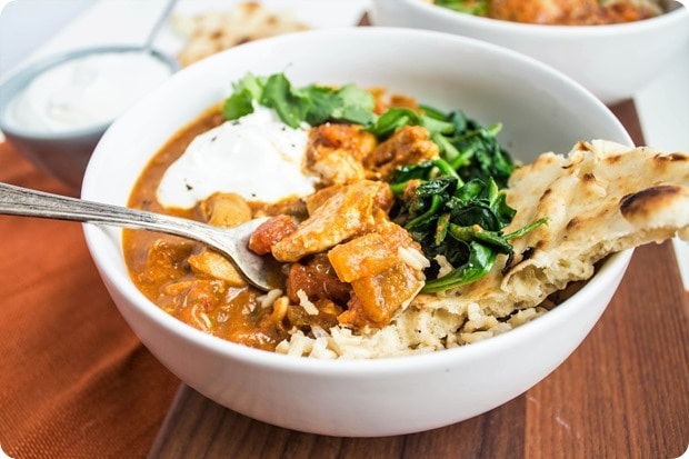 chicken tikka masala in a bowl with rice and spinach