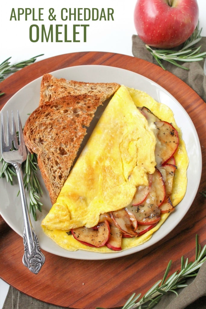 apple cheddar omelet on a plate with fresh rosemary