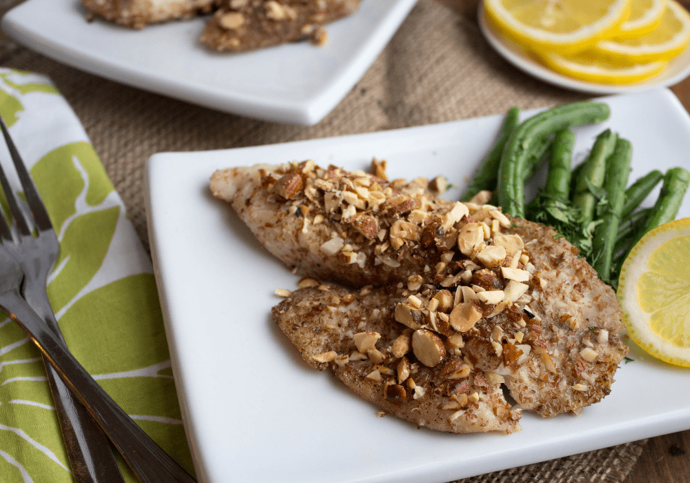 almond crusted tilapia on a white plate