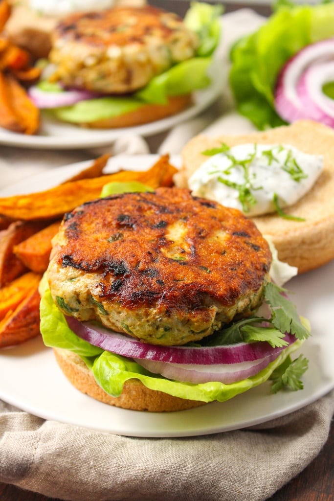 Curry Turkey Burgers with Mint Yogurt Sauce on a bun with sweet potato fries