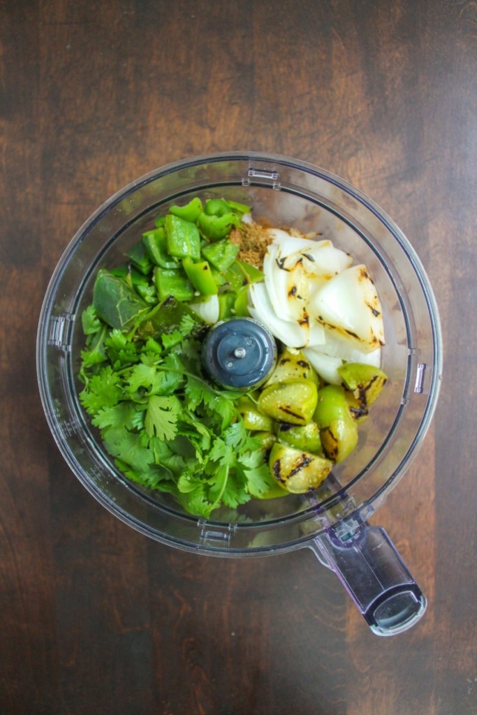 charred tomatillos, poblano peppers, jalapeno peppers, and onions with cilantro in a food processor