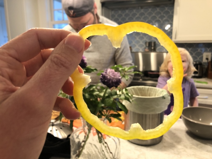 eating a yellow pepper while cooking dinner