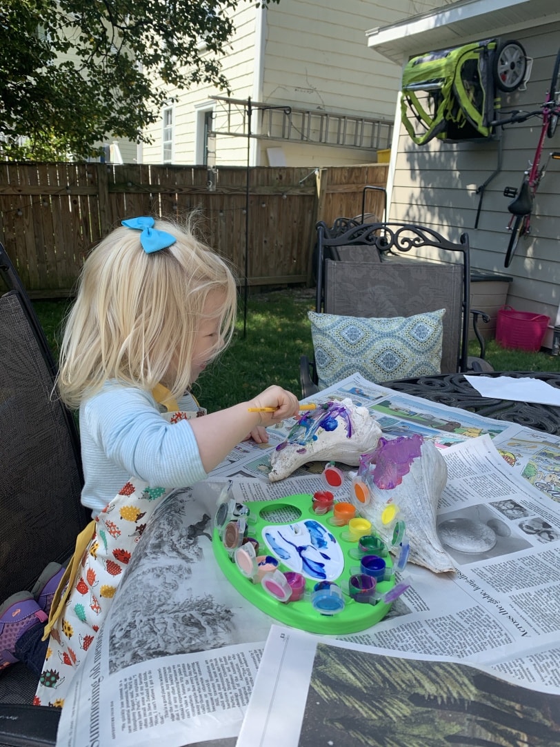 toddler painting a shell