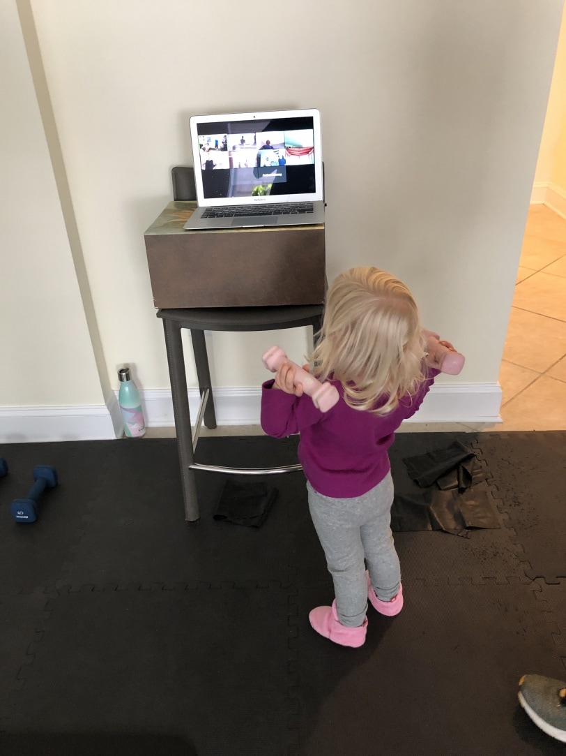 toddler holding weights and watching workout video