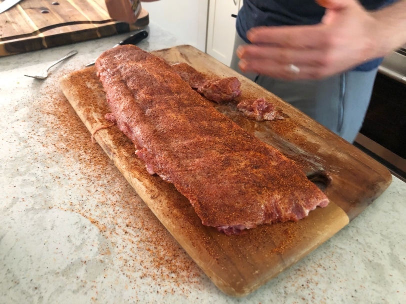 adding the spice rub to homemade ribs