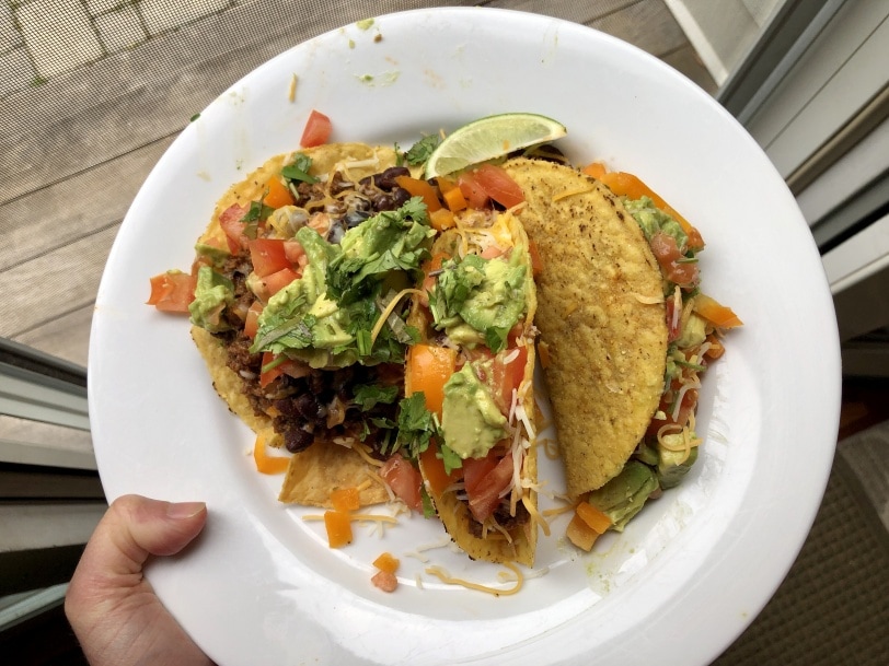 hard shell tacos with ground beef, black beans, cheese, tomato, yellow pepper, and avocado