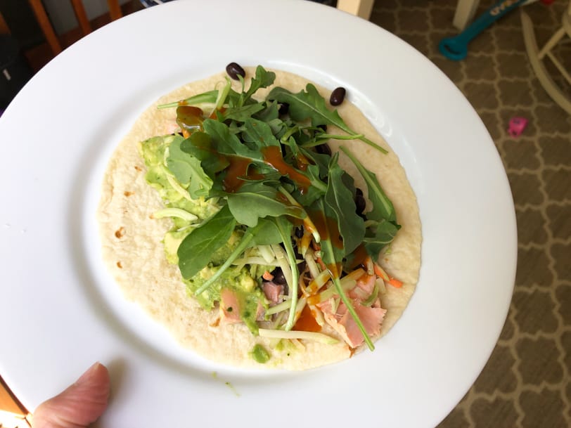 leftover salmon taco with guacamole, broccoli slaw, black beans, and arugula