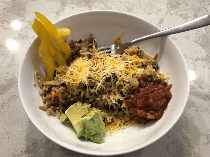 leftover mexican topped with cheese, salsa, avocado, and peppers
