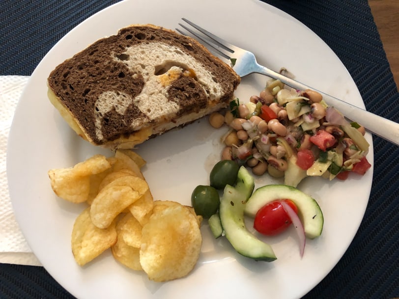 turkey reuben with bean salad, cucumber salad, and chips