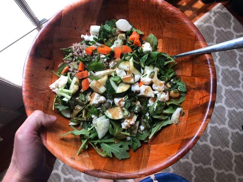 grain salad bowl with rice, feta, chickpeas, pumpkin seeds, cucumber, carrots, and balsamic vinaigrette