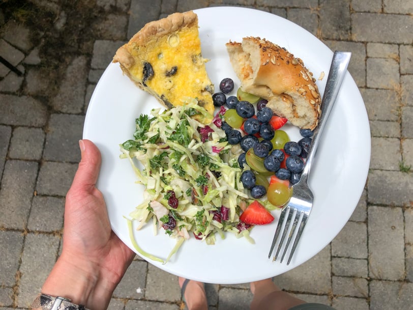 quiche, slaw salad, fruit, and bagel