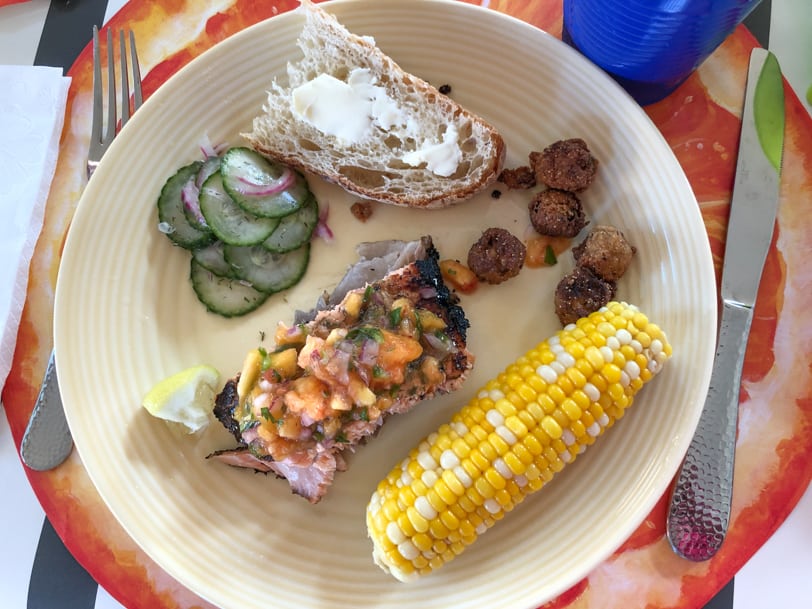 grilled salmon with corn, cucumber salad, and bread