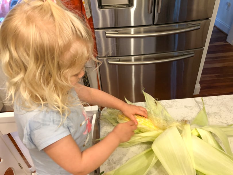 toddler shucking corn