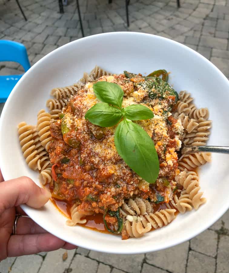 homemade pasta with meat and veggie sauce and fresh basil