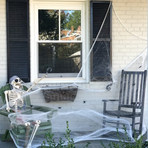 halloween decoration skeleton with cobwebs in a rocking chair