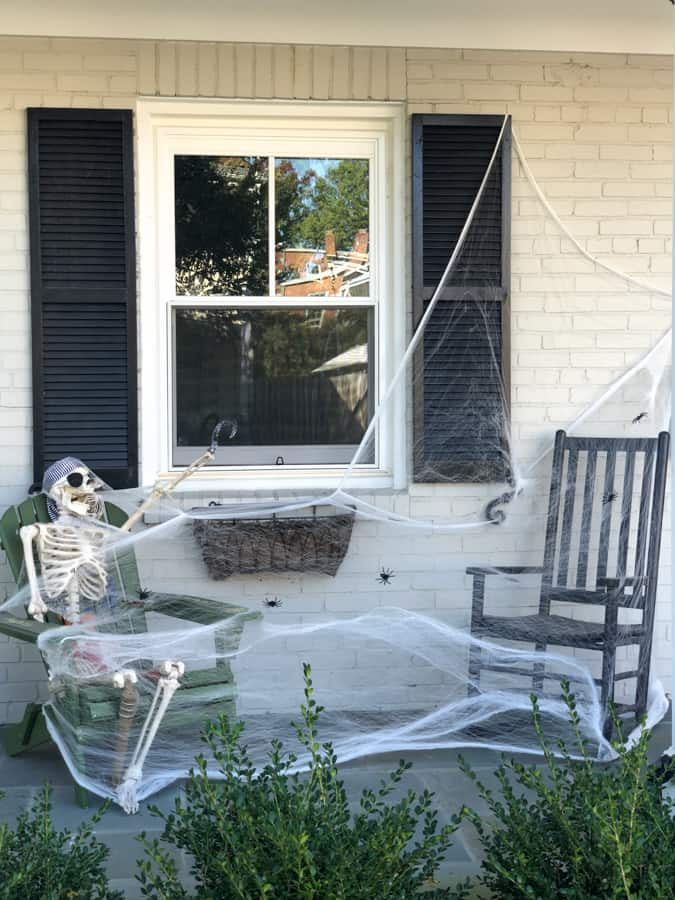 halloween decoration skeleton with cobwebs in a rocking chair