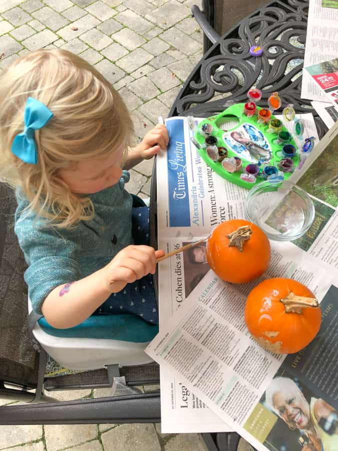 toddler painting mini pumpkins