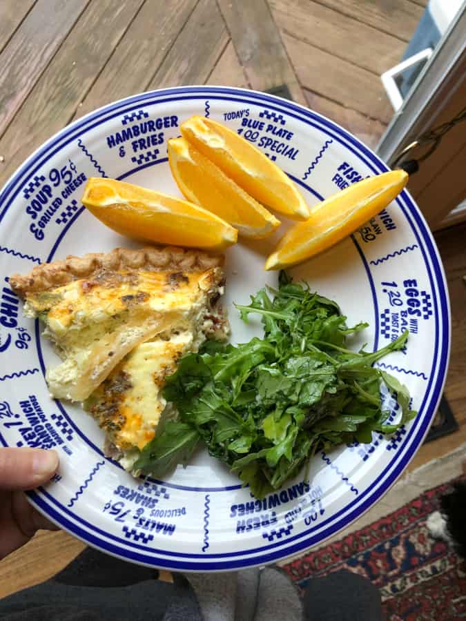 quiche with arugula salad and orange slices