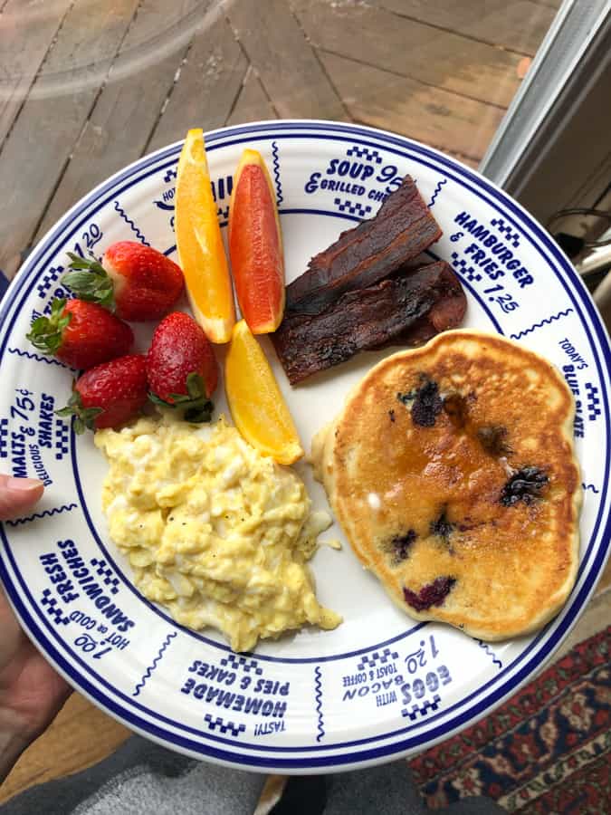 sourdough pancakes with scrambled eggs, bacon and fruit