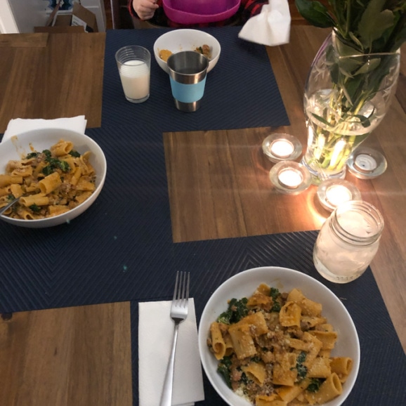 kale and sausage rigatoni dinner with candles