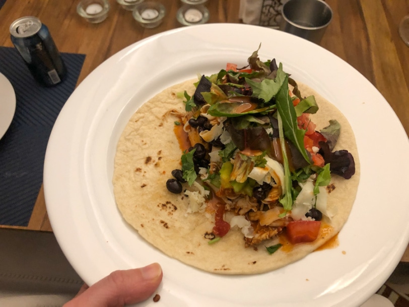 burrito filled with mexican chicken, cheese, black beans, cilantro, tomato, and lettuce