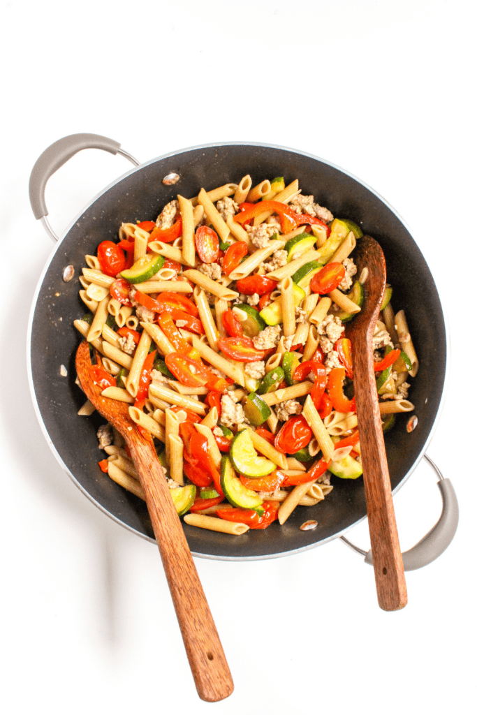 ground turkey penne pasta with vegetables in a skillet