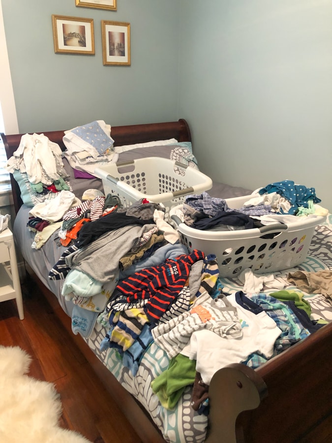 bed covered with baby boy clothes