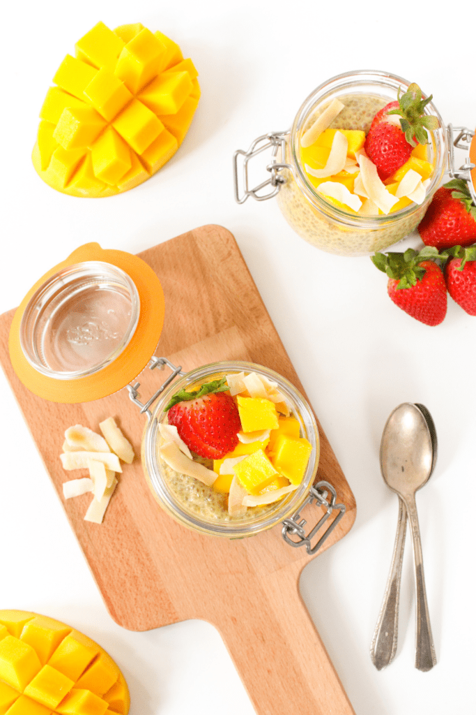 flat lay of mango chia pudding with coconut and strawberries