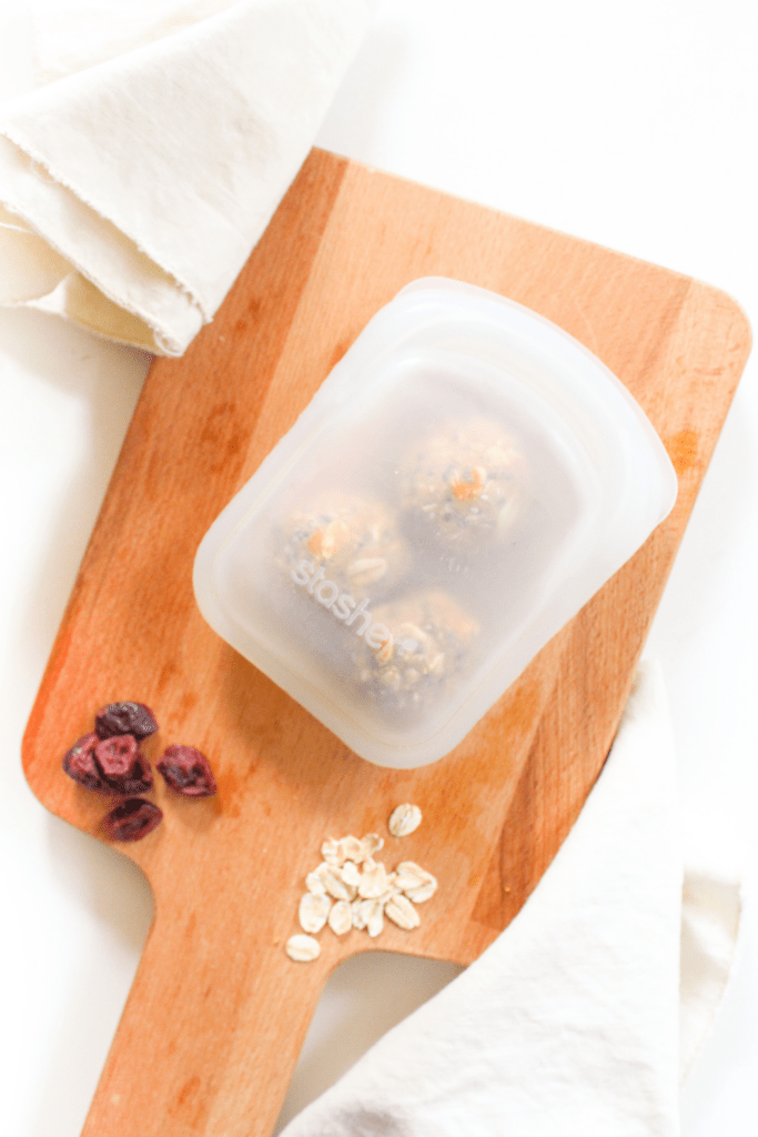 peanut butter bliss balls in a plastic storage container