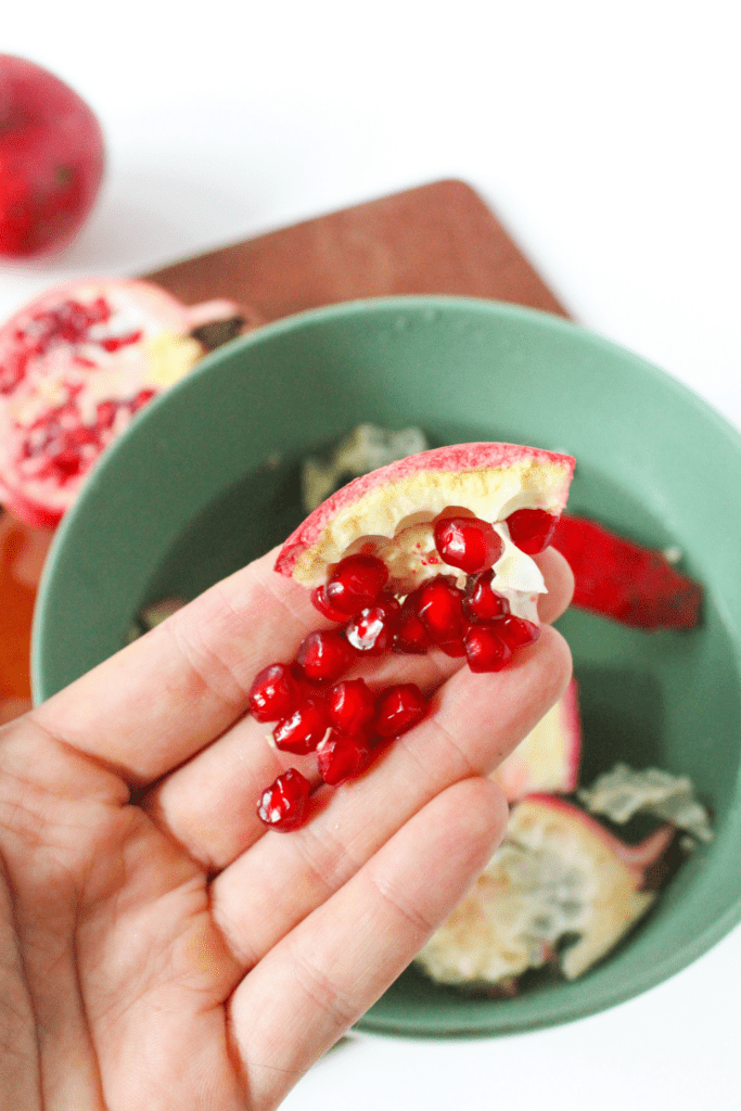peeling and seeding a pomegranate over a bowl of water