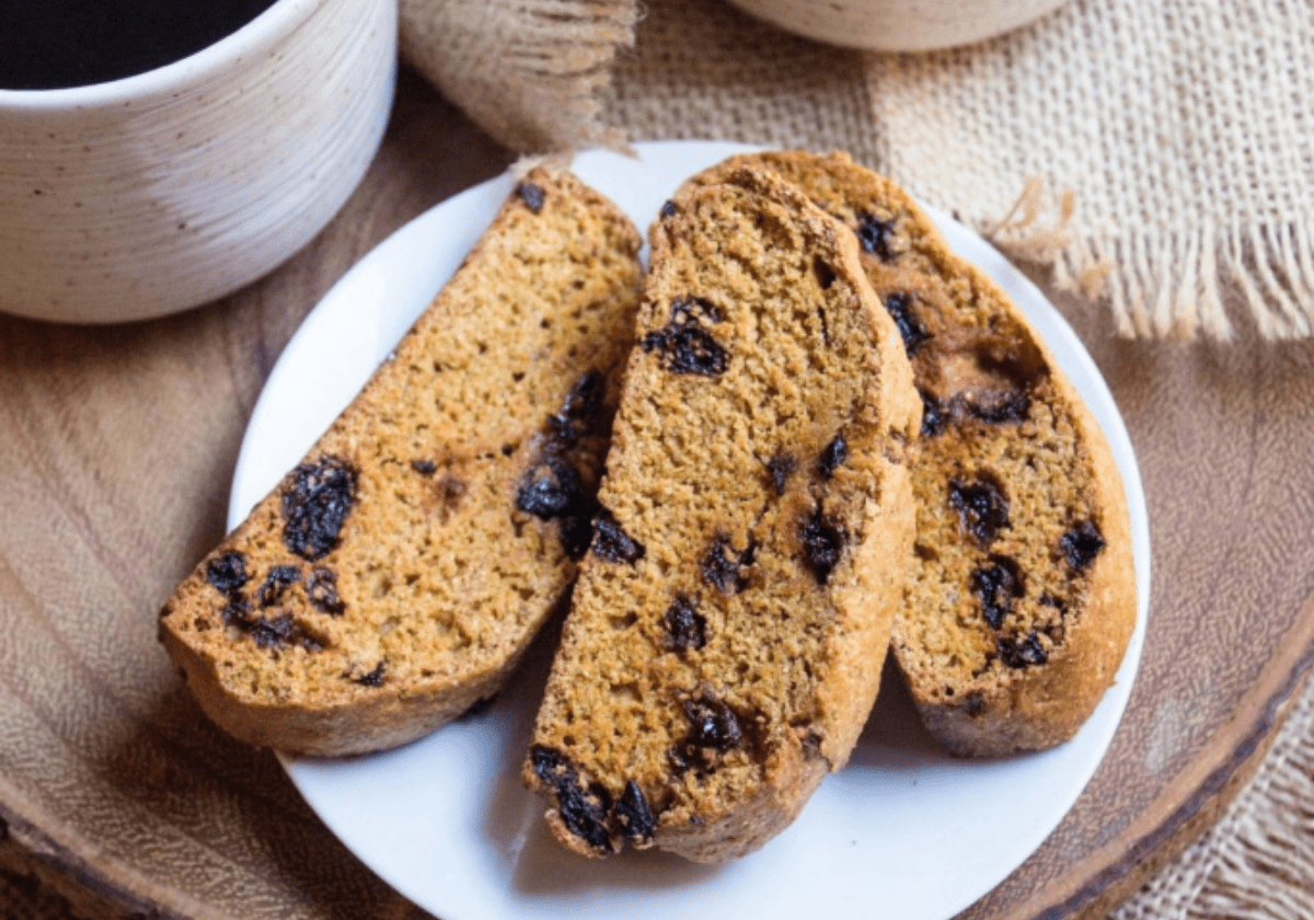 3 pieces of fall pumpkin biscotti with goji berries on a white plate