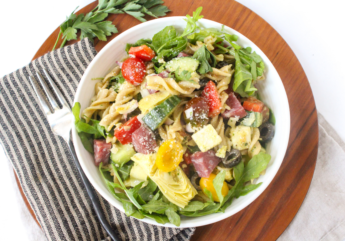 pasta salad with greens and veggies in a bowl