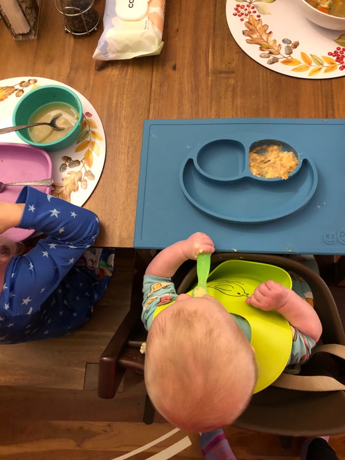 baby in chair eating peanut butter yogurt