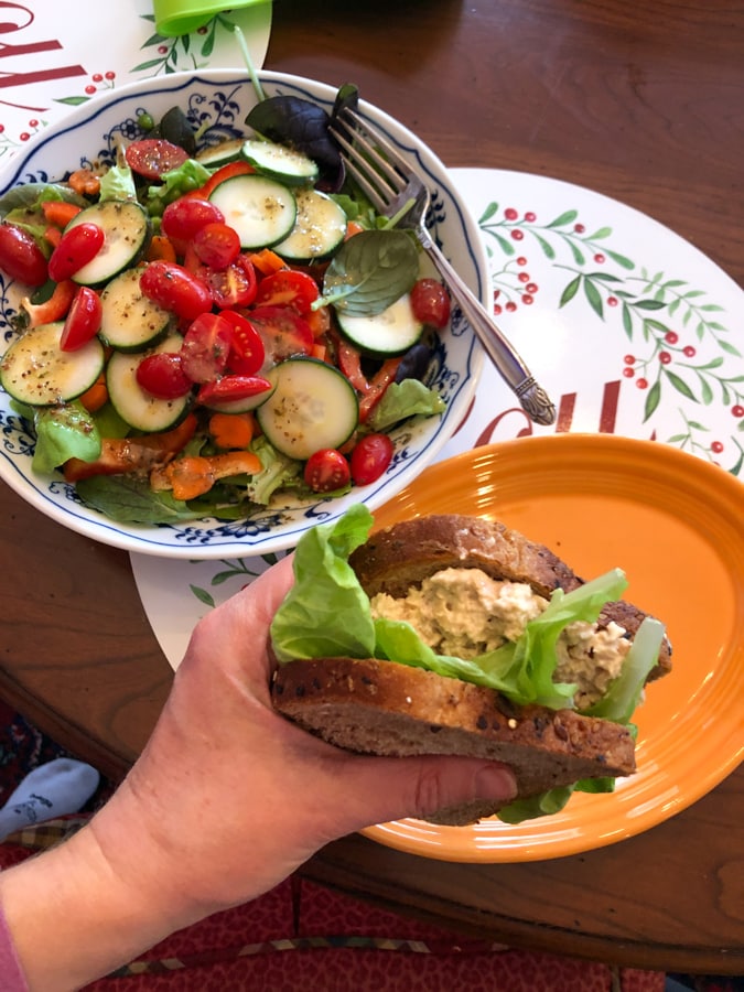 salmon salad sandwich with a side salad