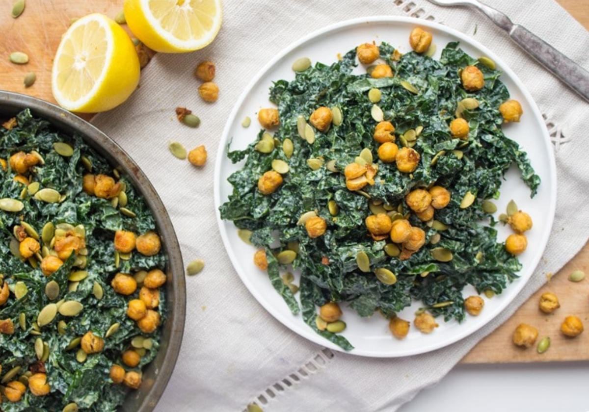 vegan kale caesar salad on a white plate on a wooden platter