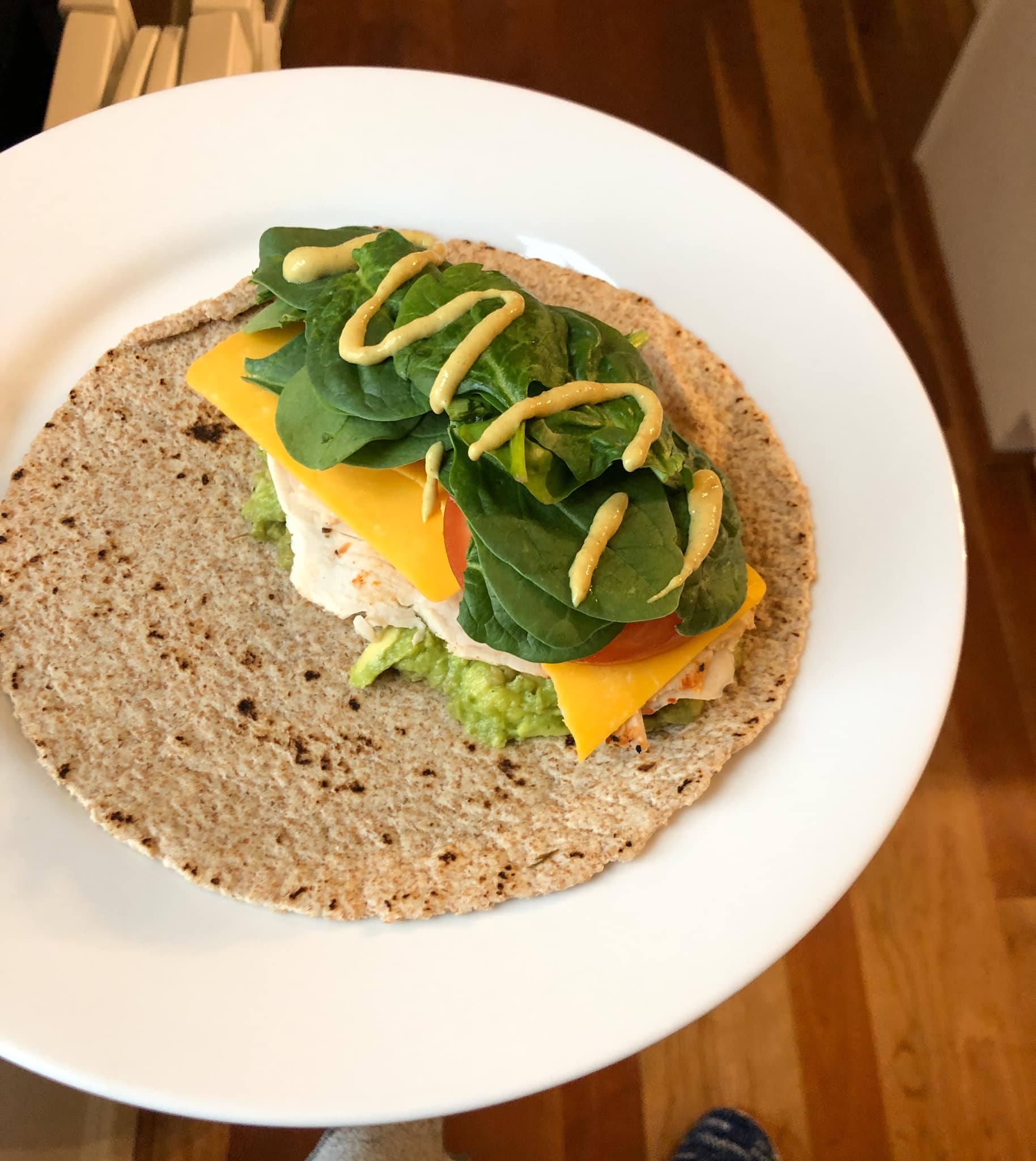 wrap with mustard, guacamole, turkey, cheddar cheese, tomato, and spinach
