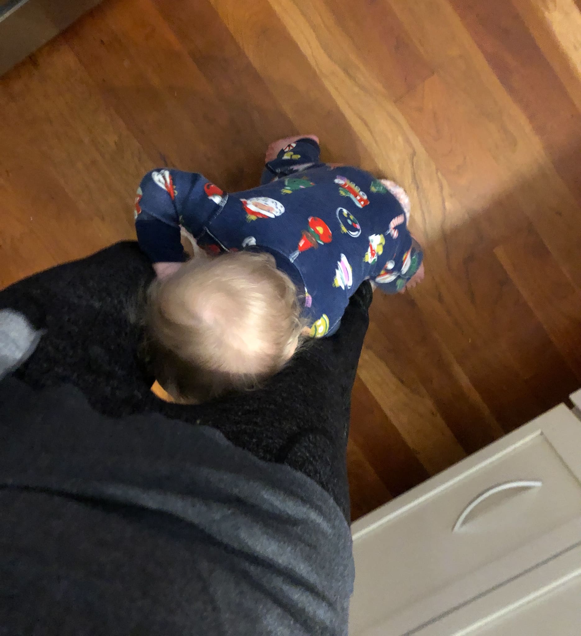 baby holding on to mom's legs