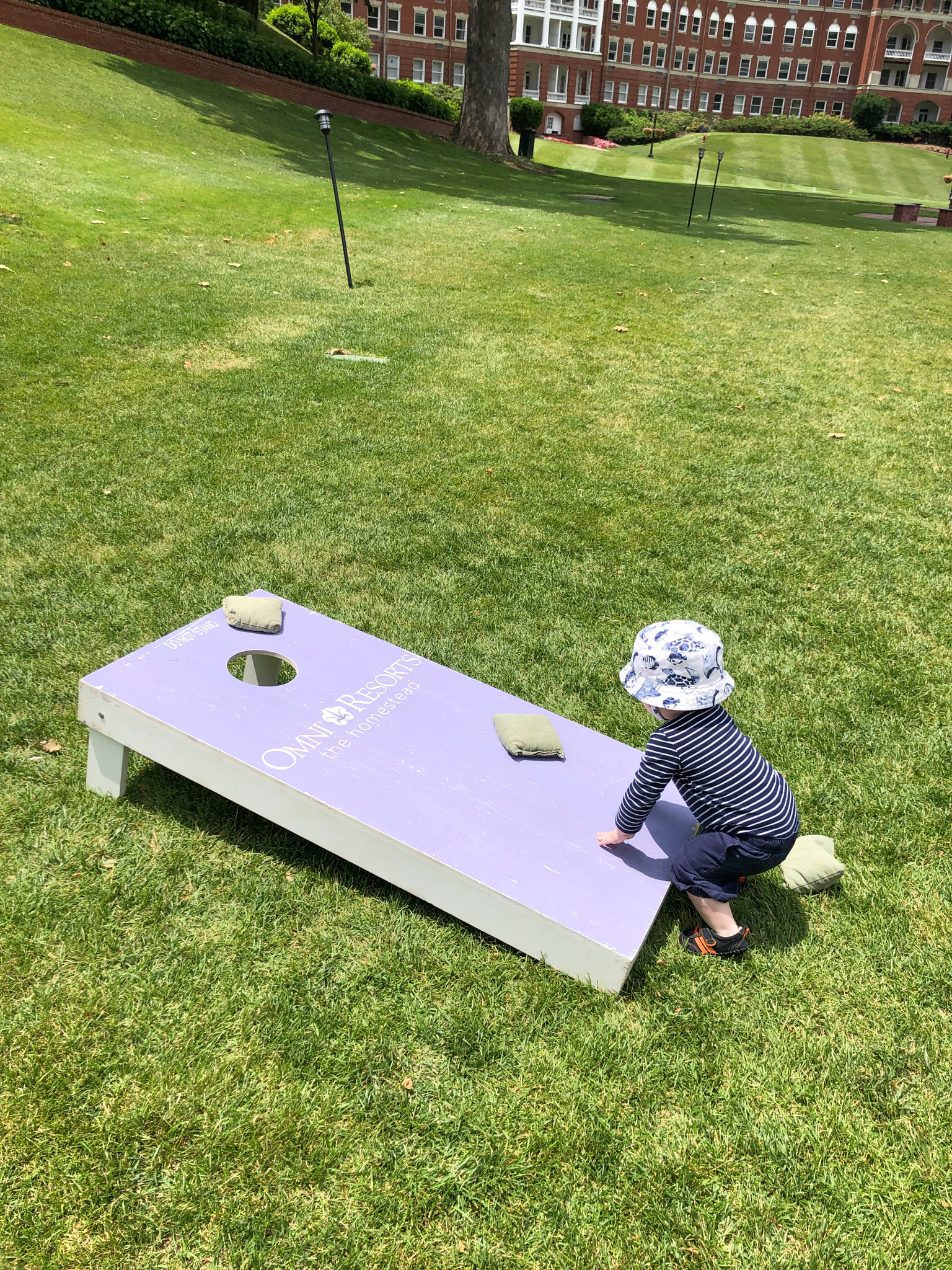 baby playing cornhole