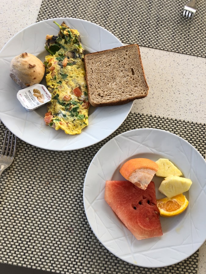 omelette with veggies and fruit on a plate.