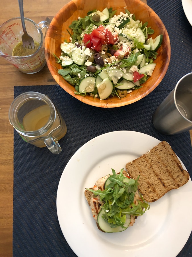 greek burgers and greek salad on a table.