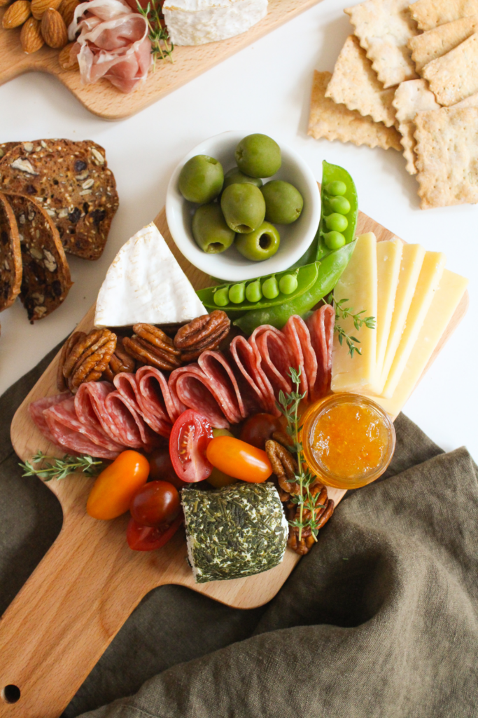 small cheese board with vegetables, pecans, and salami
