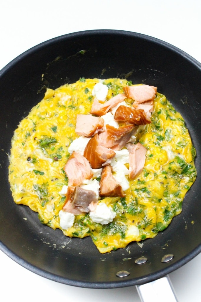egg mixture in a skillet with goat cheese and smoked salmon