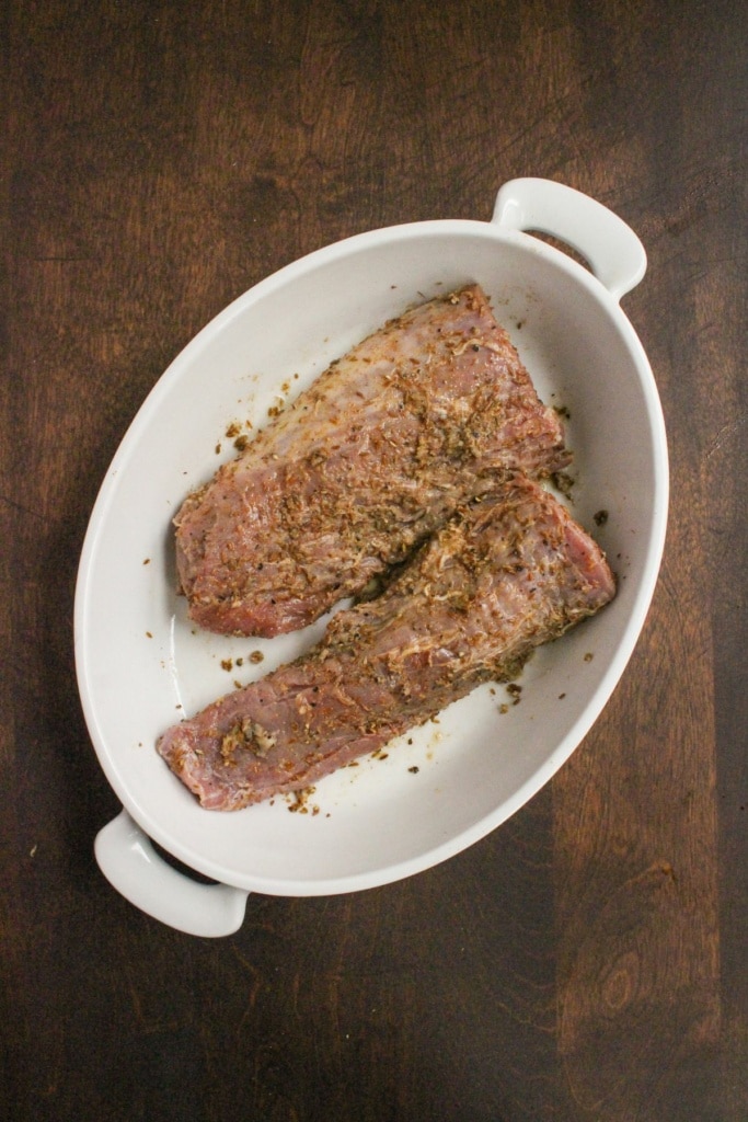 marinated pork tenderloin in a white baking dish